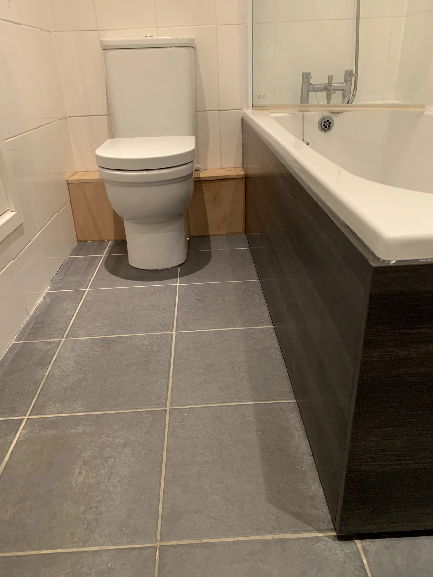 Bathroom refurbishment with tiled floor and fitted bath