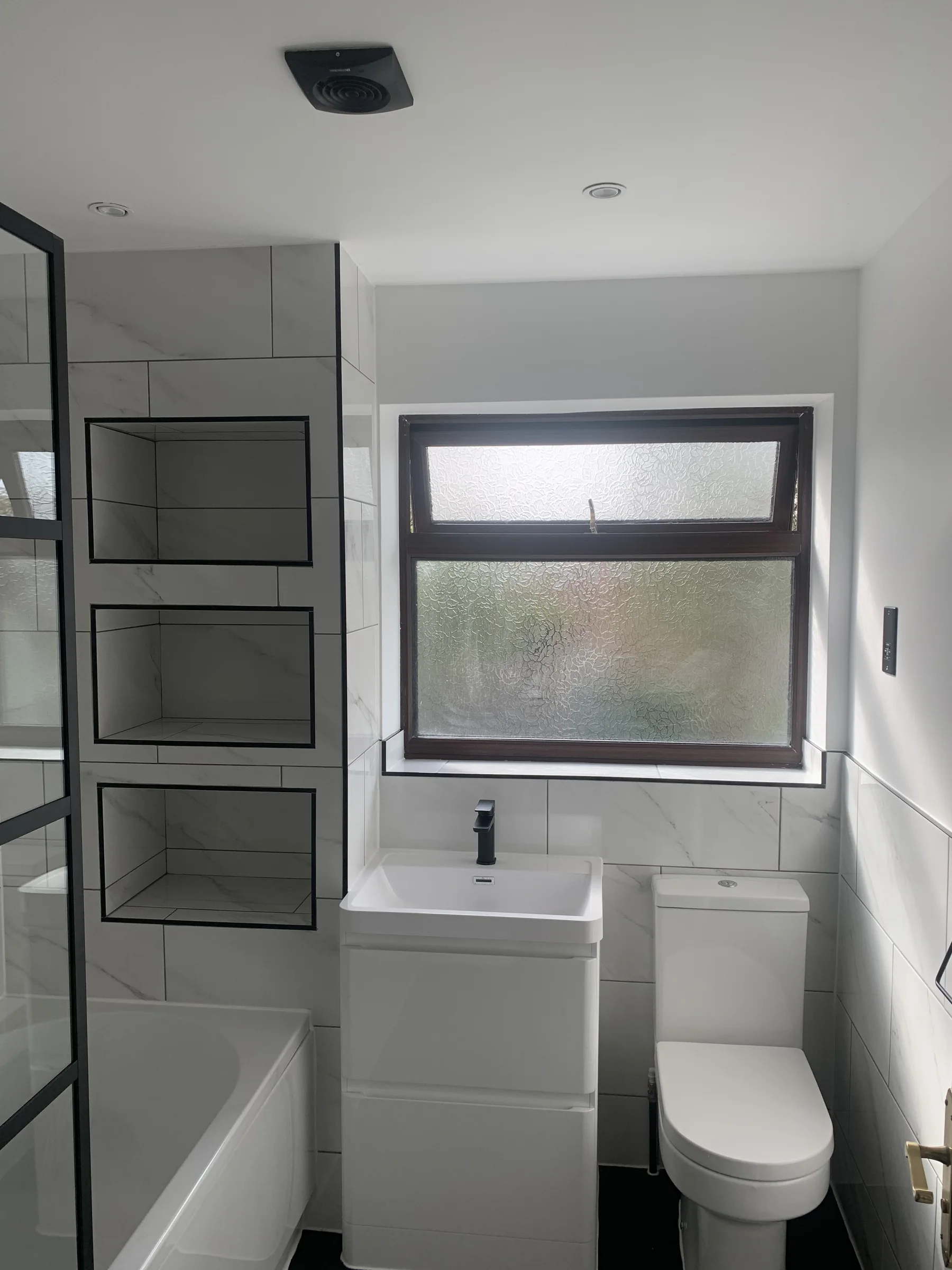 Finished bathroom with recessed tiled storage