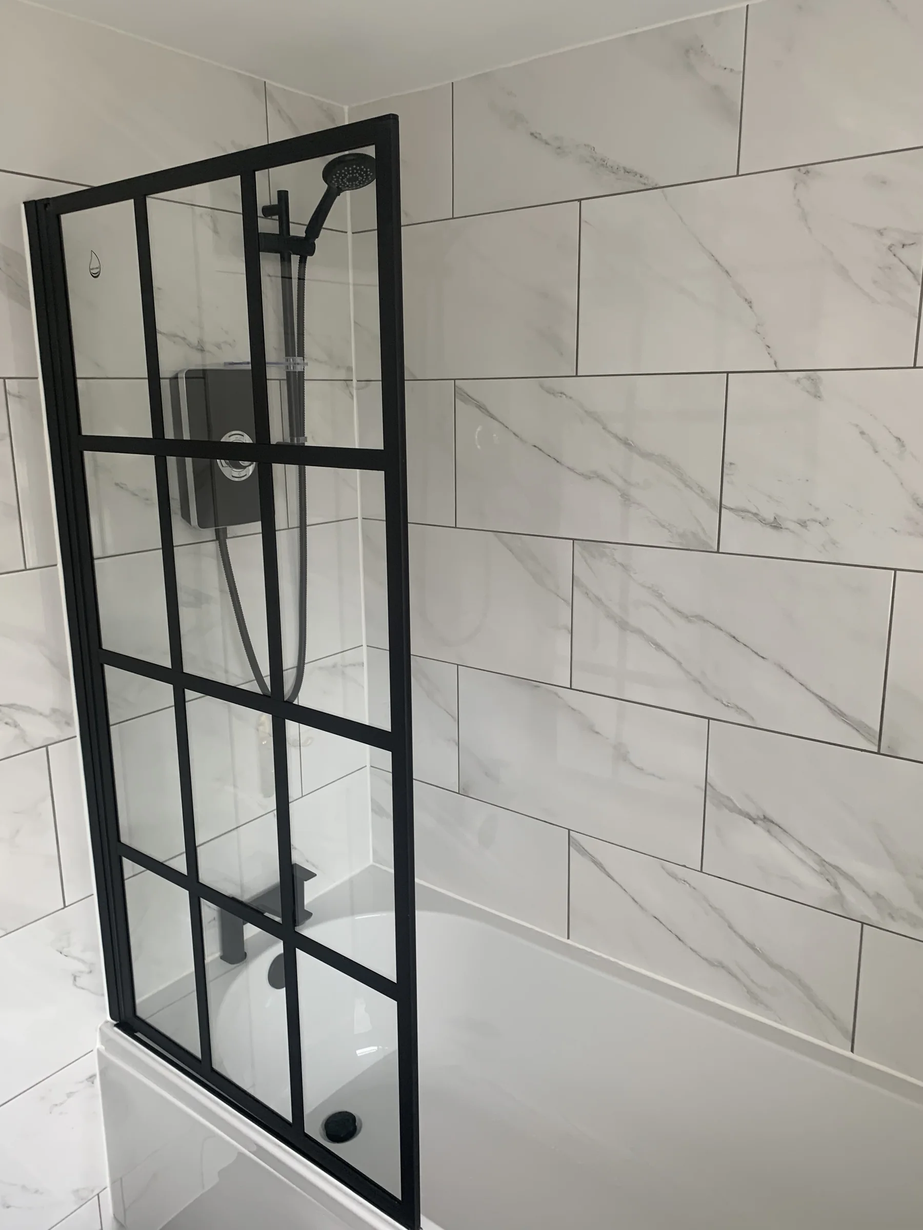 Black framed shower screen and marble-effect tiling