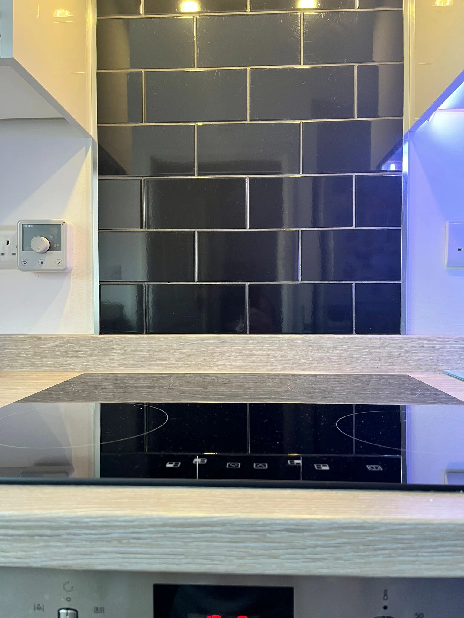 Gloss black tiled kitchen splashback installed by Nick's Home Improvements